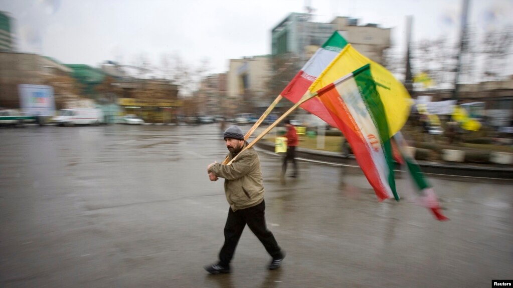 حمل پرچم‌های ایران و حزب‌الله در مراسمی حکومتی که به مناسب کشته‌شدن عماد مغنیه، از رهبران این گروه در ایران برگزار شده بود