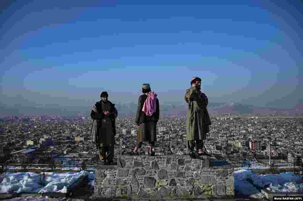 Members of the Taliban stand on a plinth overlooking the Afghan capital, Kabul.&nbsp;