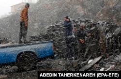 کارگران افغان در یک روز برفی زمستان در شهر میگون در شمال تهران.