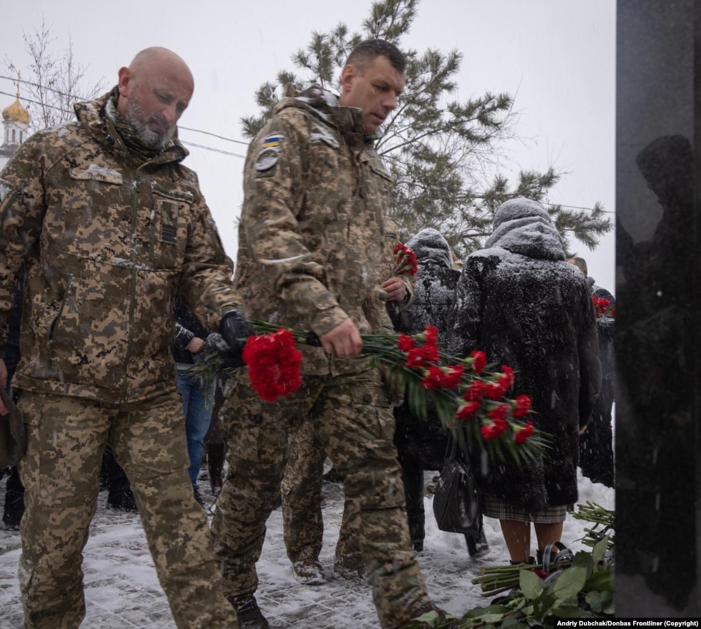 Ushtarë ukrainas duke vënë lule më 24 janar te një memorial për viktimat e një sulmi me raketë, i cili vrau 31 persona në Mariupol, shtatë vjet më parë.