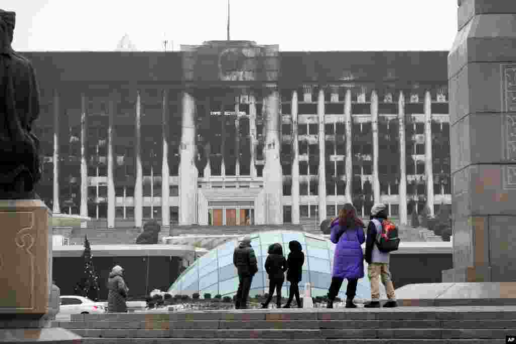 Locals look at the charred city hall building in Almaty&#39;s central square on January 11.&nbsp;