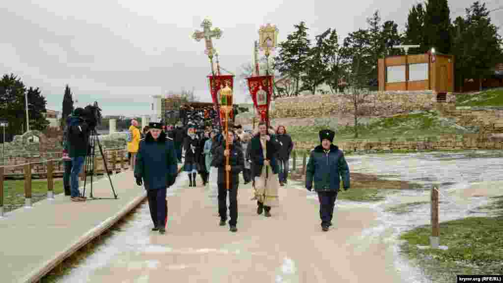 Люди идут от Владимирского собора к берегу Карантинной бухты, где запланировано купание