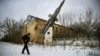 Мужчина проходит мимо разрушенного здания бывшей военной базы в селе Веселое, пригород Донецка