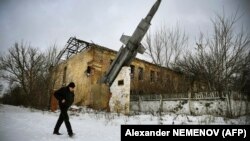 Мужчина проходит мимо разрушенного здания бывшей военной базы в селе Веселое, пригород Донецка