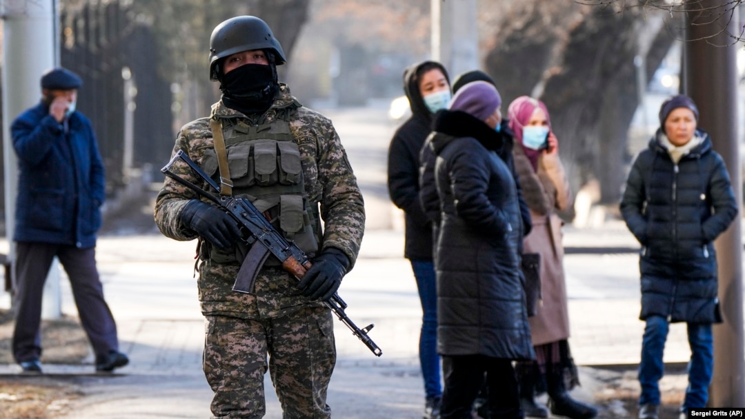 A Kazakh soldier patrols a street as relatives of the arrested in the anti-government protests gather near a police station in Almaty.