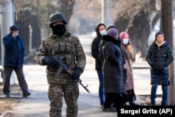 A soldier patrols a street in Almaty on January 14 as relatives of those arrested during and after the protests gather near a police station.