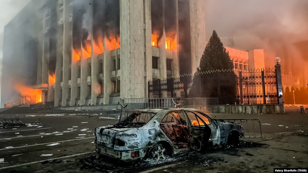 Сгоревший автомобиль возле горящего здания акимата Алматы 5 января 2022 года