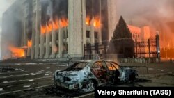 Сгоревший автомобиль возле горящего здания акимата Алматы. 5 января 2022 года