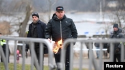 Rasmus Paludan, politikan i ekstremit të djathtë në Suedi, duke djegur një kopje të Kuranit. Janar, 2023.