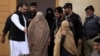 Pakistani security officials escort Sharbat Gula (center, in burqa), after a court hearing in Peshawar on November 4.