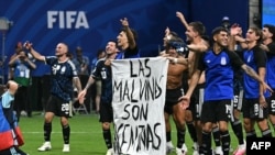 Jucătorii argentinieni cu bannerul cu mesaj politic, după ce au câștigat meciul din semifinala Cupei Mondiale de fotbal din 2026 dintre Anglia și Argentina, la Atlanta, pe 15 iulie 2026.