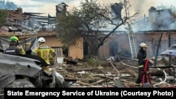 Rescuers work at the site of a Russian missile strike on the Kyiv region, where attacks on July 24 left at least 10 dead. 
