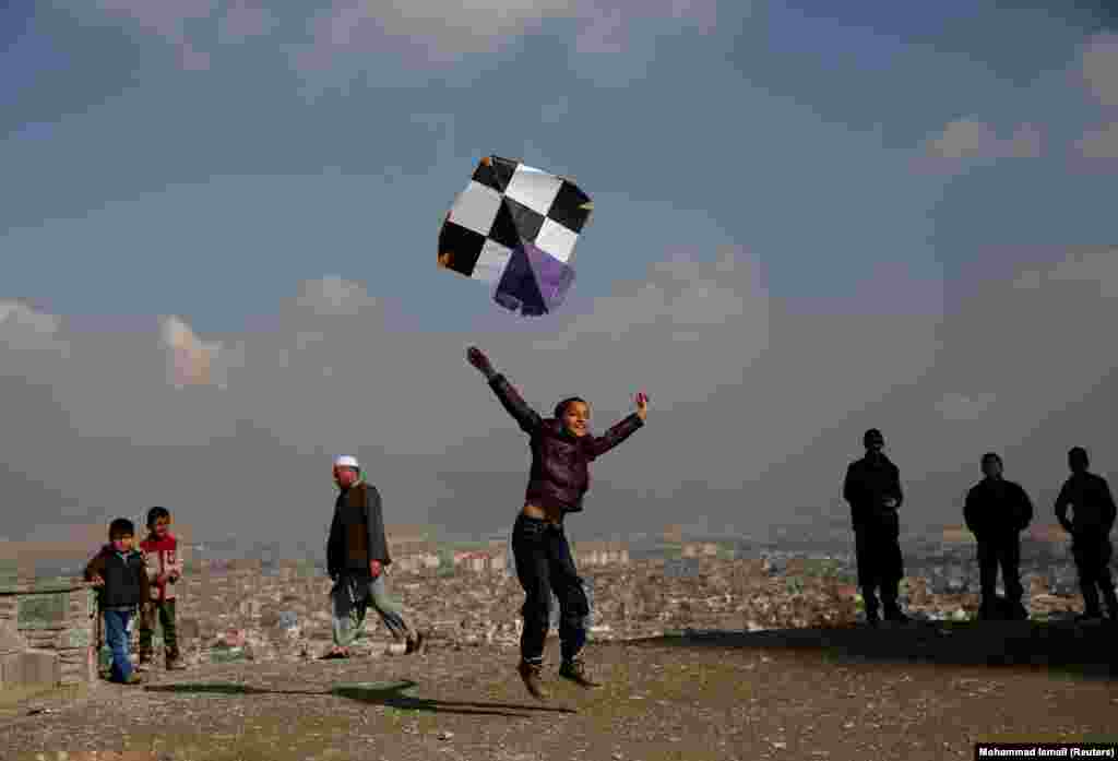 An Afghan boy launches a kite as he plays on top of a hill in Kabul. (Reuters/Mohammad Ismail)