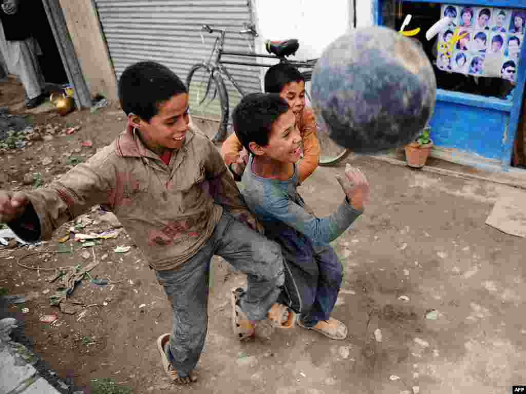 Afghan boys scuffle as they play football in a street in Kabul on July 28. Photo by Yuri Cortez for AFP