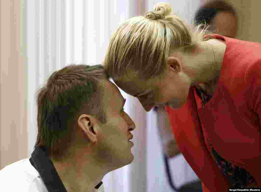 Navalny and his wife, Yulia, during a break in court proceedings in Kirov in July 2013. Navalny was charged with stealing 16 million rubles ($500,000) from a state timber firm. He rejected the charges as trumped up. The court handed down a five-year prison term that was later reduced to a suspended sentence after widespread public protests. &nbsp;