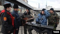 Cossack militia members (left) check out street musicians at the entrance to a Moscow subway station on November 14.