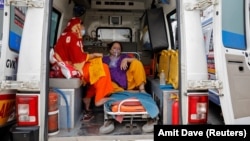 Пациентка с кислородной маской в машине скорой помощи в Индии.