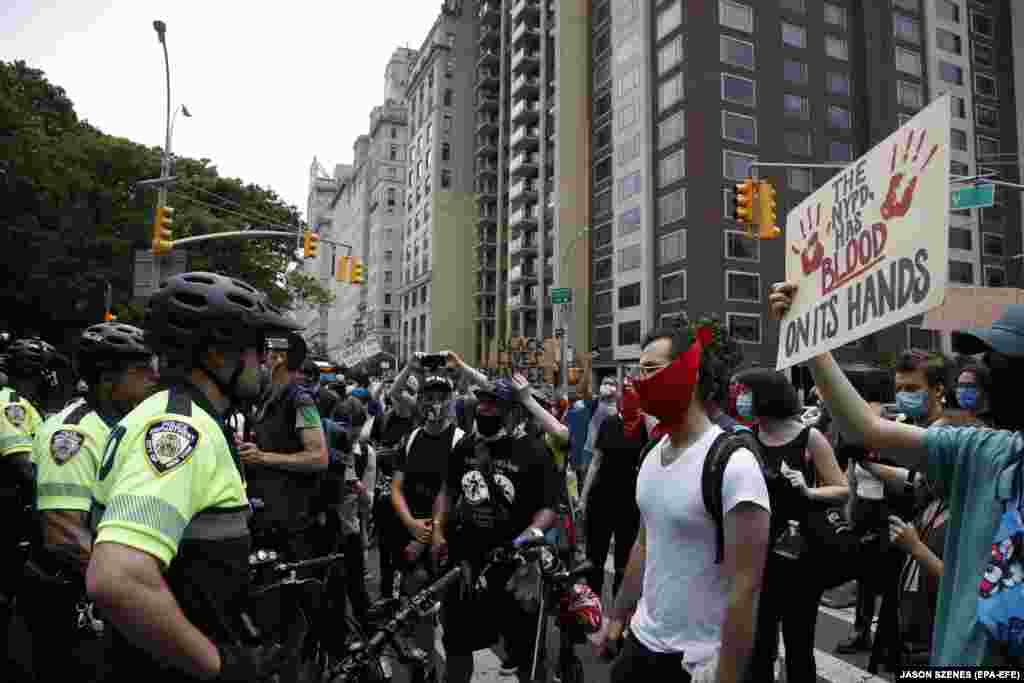 Protestors yell at members of the New York City Police Department while demonstrating down Fifth Avenue's museum mile in New York, USA, 11 June 2020, over the death of George Floyd.
