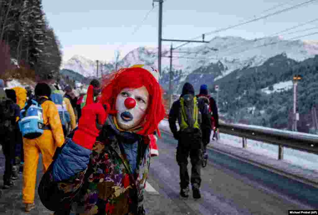 A man dressed as a clown is one of hundreds of climate protesters at the Davos economic conference in Switzerland. (AP/Michael Probst)