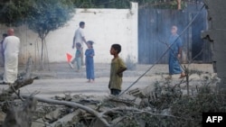 People inspect the damage following Israeli bombardment in Nuseirat, in the central Gaza Strip, on August 12.