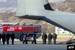 Policë zviceranë, duke transportuar një arkivol në bordin e një avioni C-130 Hercules të Forcave Ajrore Italiane, gjatë riatdhesimit të trupave të pesë prej gjashtë shtetasve italianë që humbën jetën në tragjedinë e zjarrit të Vitit të Ri.