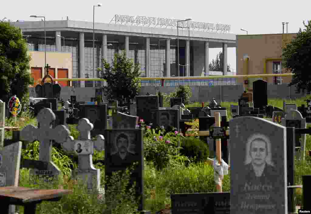 The terminal of Donetsk international airport is seen behind a cemetery.
