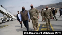 U.S. Defense Secretary Lloyd Austin (second left) walks with U.S. military personnel upon arriving for an unannounced visit to Kabul on March 21 to assess the security situation.