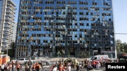 Lucrători ai echipelor de urgență lucrează în Ramat Gan, la locul unei lovituri iraniene.