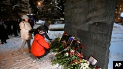 Хората се събират, за да положат цветя в памет на Алексей Навални върху мемориала на Стената на скръбта на жертвите на политическите репресии в Москва, Русия, петък, 16 февруари 2024 г.