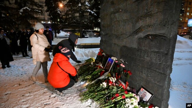 Хората се събират, за да положат цветя в памет на Алексей Навални върху мемориала на Стената на скръбта на жертвите на политическите репресии в Москва, Русия, петък, 16 февруари 2024 г.