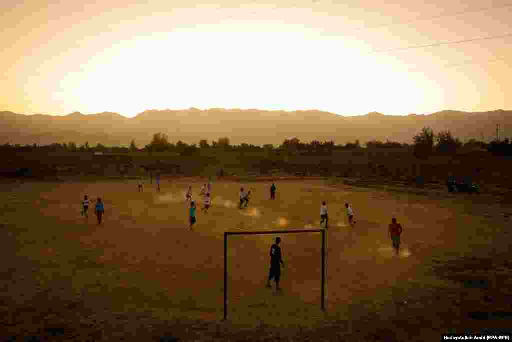 Afghan children play soccer in a field near a village on the outskirts of Kabul. (epa-EFE/Hedayatullah Amid)