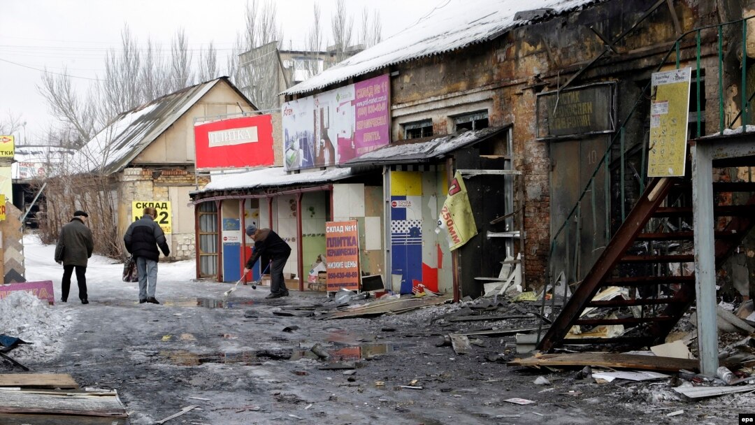 Донецк. Мужчина убирает улицу после обстрела