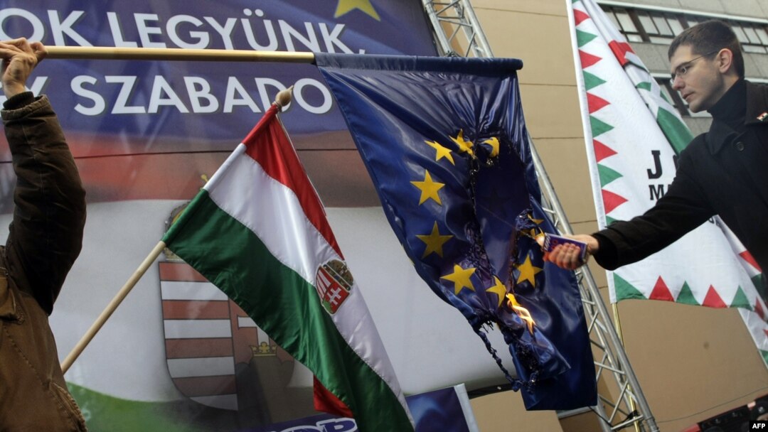 Пратеникот Елод Новак од унгарската десничарска партија Јобик го пали знамето на ЕУ на протестот „Да бидеме членка или да бидеме слободни?“ во Будимпешта на 14 јануари 2012 година.