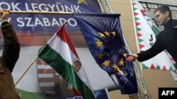 Пратеникот Елод Новак од унгарската десничарска партија Јобик го пали знамето на ЕУ на протестот „Да бидеме членка или да бидеме слободни?“ во Будимпешта на 14 јануари 2012 година.
