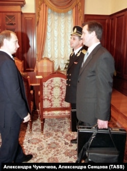Исполняющий обязанности президента России Владимир Путин принимает ядерный чемоданчик (внизу справа) в Кремле поздно вечером 31 декабря 1999 года