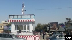 Кундуз қаласындағы бақылау бекеттерінің төбесіне тігілген Талибан туы.