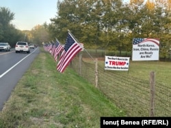 O fermă din statul Pennsylvania pe al cărei gard apar mai multe steaguri ale SUA și panouri electorale pro-Trump.