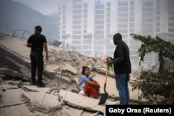 Një grua reagon ndërsa njerëzit kërkojnë viktima mes rrënojave të ndërtesave të shembura, pas tërmeteve në Venezuelë, 25 qershor 2026.