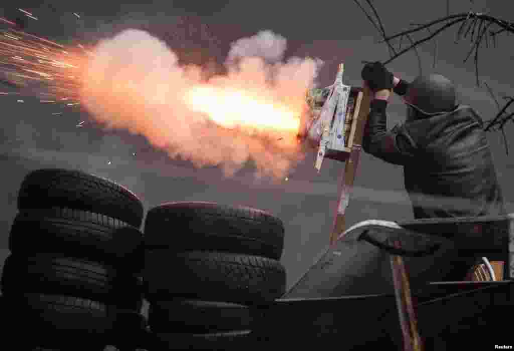 An antigovernment protester shoots an improvised device.