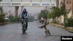 A resident rides his bicycle near what activists said was an exploded cluster bomb shell in the town of Douma, north-east of Damascus in November.