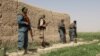 Afghan policemen keep watch during a battle with the Taliban in the Nahr-e Saraj district of Helmand Province on May 11.