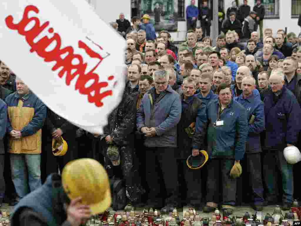 Працоўныя Гданьскай судавэрфі трымаць кветкі і сьвечкі ў памяць пра загіблых 