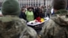 People attend a farewell ceremony to a volunteer soldier of the separate assault battalion Carpatian Sich, Andriy Romanyuk, 26, on Independence Square in Kyiv on November 1.