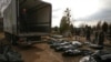 A funeral service employee looks at bodies of civilians, brought from the streets to the local cemetery, in the town of Bucha on April 6.