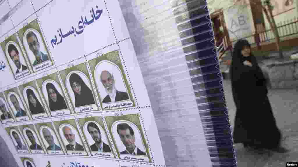 An Iranian woman in central Tehran walks past electoral posters for Iran&#39;s upcoming parliamentary elections. (REUTERS/Morteza Nikoubazl)