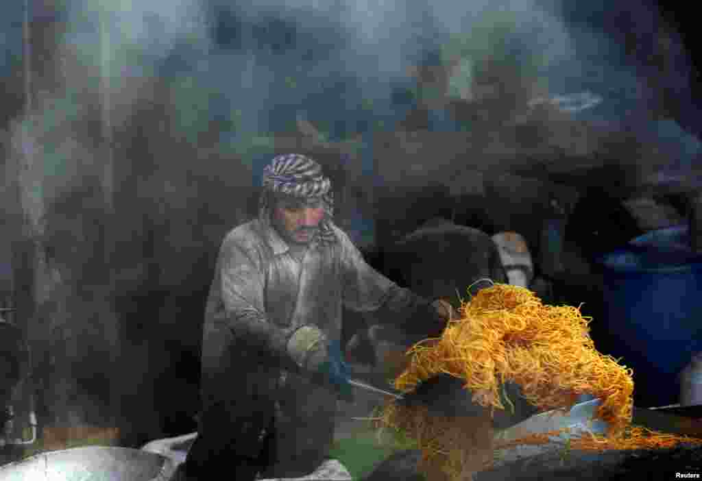 An Afghan man makes sweets at a traditional factory during the holy Muslim fasting month of Ramadan in preparation for Eid al-Fitr in Kabul. (Reuters/Omar Sobhani)