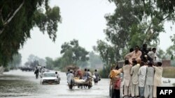 Residents evacuate from a waterlogged area of Humayun, near Jacobabad, today.