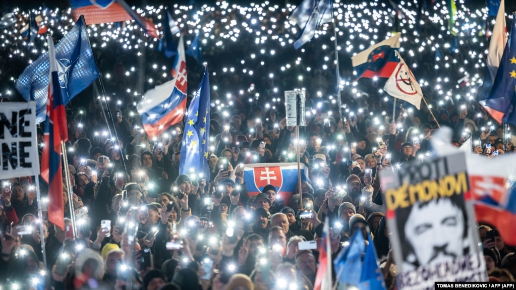 Mọi người giơ cao đèn, cờ Slovakia và EU khi tham gia cuộc biểu tình chống chính phủ tại Quảng trường Tự do của Bratislava, ngày 7 tháng 2 năm 2025.