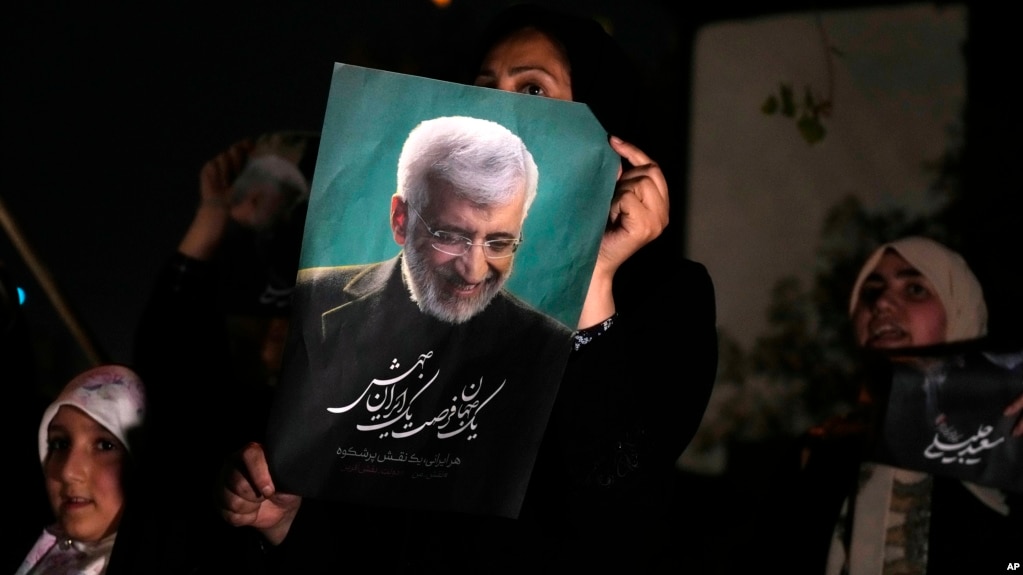 Saeed Jalili's supporters hold up one of his campaign posters ahead of Iran's presidential election on June 28. Jalili finished second among four candidates and will head to a run-off vote on July 5. 