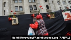 People lay flowers at the labor-union building where a fire killed 43 people inside a year ago. 